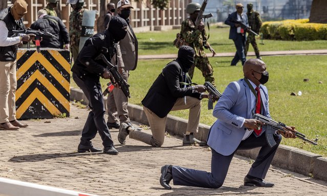 Kenya Police officers and security personnel take position to protect the Kenyan Parliament as protesters try to storm the building during a nationwide strike to protest against tax hikes and the Finance Bill 2024 in downtown Nairobi, on June 25, 2024. Kenyan police shot dead one protester near the country's parliament Tuesday, a rights watchdog said as demonstrators angry over proposed tax hikes breached barricades and entered the government complex, where a fire erupted. The mainly Gen-Z-led rallies, which began last week, have taken President William Ruto's government by surprise, with the Kenyan leader saying over the weekend that he was ready to speak to the protesters. (Photo by Luis Tato/AFP Photo)