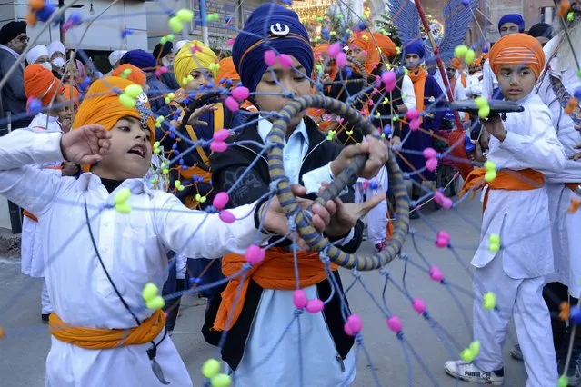 Sikh youth perform “Gatka”, an ancient form of Sikh martial arts during a religious procession on the eve of martyrdom day of the ninth Sikh Guru Tegh Bahadur in Amritsar on December 18, 2020. (Photo by Narinder Nanu/AFP Photo)