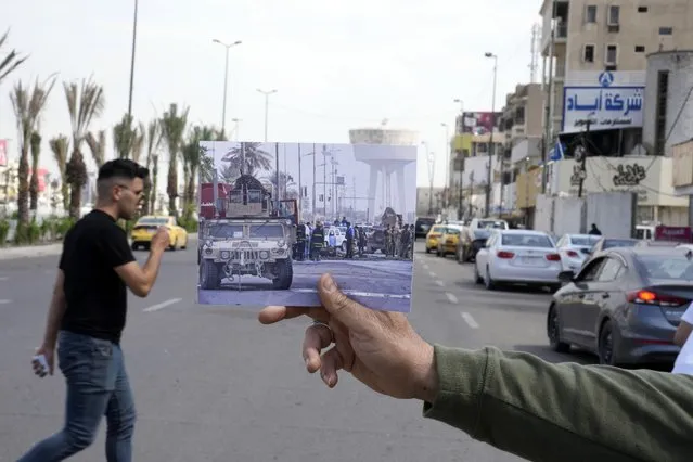 A photograph of a army vehicle securing the area where a suicide car bomber targeted a government convoy, in Bab al-Sharji area, central Baghdad, Thursday, Oct. 23, 2008, is inserted into the scene at the same location on Tuesday, March 21, 2023, 20 years after the U.S. led invasion on Iraq and subsequent war. (Photo by Hadi Mizban/AP Photo)