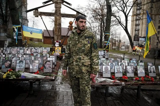 A serviceman reacts during a commemoration ceremony at the site where anti-Yanukovich protesters were killed during clashes in Kiev, Ukraine, November 21, 2015. Ukrainians marked the second anniversary of Ukrainian pro-European Union (EU) mass protests which caused a change in the country's leadership and brought Ukraine closer to the EU. (Photo by Gleb Garanich/Reuters)