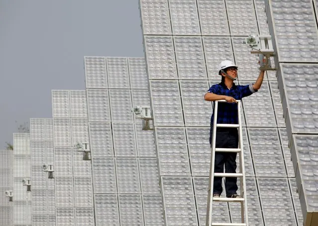 A worker checks a panel at a high-concentration photovoltaic (HCPV) solar energy power plant in Lujhu Township of Kaohsiung County, southern Taiwan, in this January 22, 2010 file photo. (Photo by Nicky Loh/Reuters)