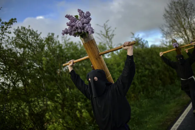 Masked penitents hold their crosses during spring “Romeria Cruceros de Arce”, while they walk through the small Pyrenees village of Villanueva de Arce and Roncesvalles Church, northern Spain, Sunday, May 13, 2018. Every year on the second Sunday in spring, people with crosses march from their small Pyrenees towns to Roncesvalles Church in tribute of the Virgin. (Photo by Alvaro Barrientos/AP Photo)