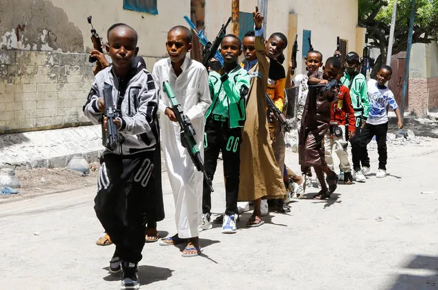 Somali children parade with replicas of guns during the Eid al-Fitr celebrations, marking the end of the fasting month of Ramadan, in Waberi district of Mogadishu, Somalia on April 21, 2023. (Photo by Feisal Omar/Reuters)