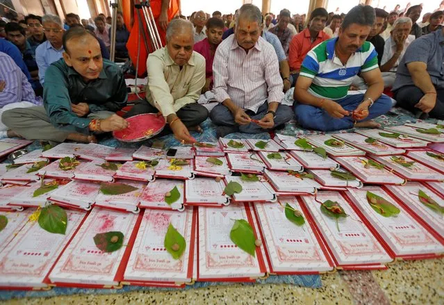 Indian businessmen pray in front of their record-keeping books as part of a ritual to worship the Hindu deity of wealth goddess Lakshmi on Diwali, the festival of lights, in Ahmedabad, India, October 30, 2016. (Photo by Amit Dave/Reuters)
