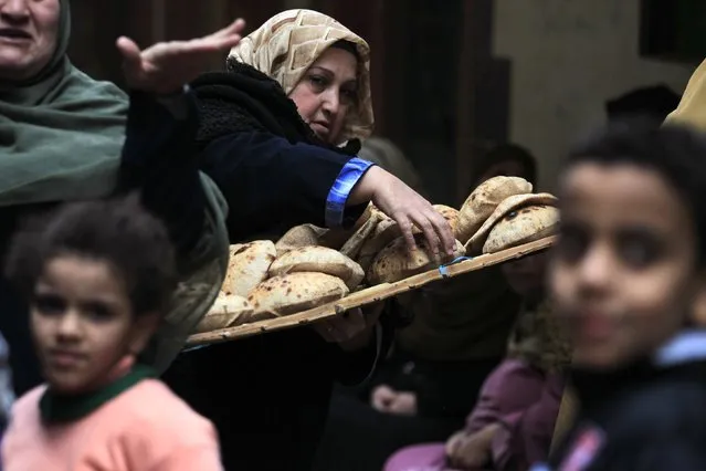 A woman arranges bread after purchasing it at a bakery in Cairo, January 8, 2015. (Photo by Mohamed Abd El Ghany/Reuters)