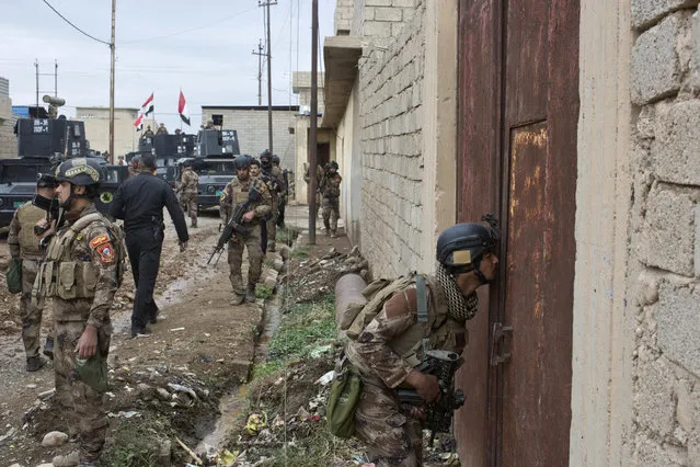 An Iraqi special forces soldier peeks through a hole in a door as his unit gets ready to search a compound in Gogjali, an eastern district of Mosul, Iraq, Wednesday, November 2, 2016. (Photo by Marko Drobnjakovic/AP Photo)