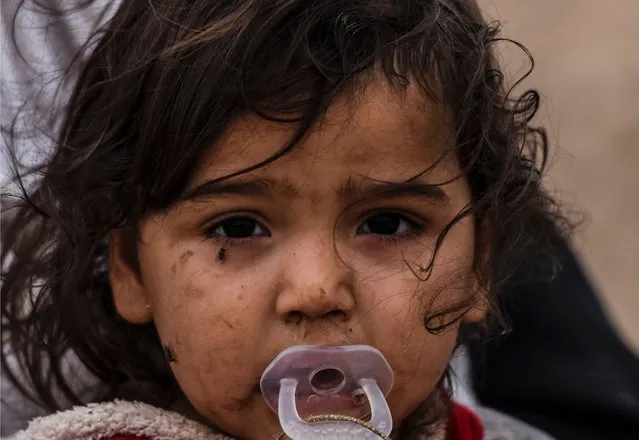 An Iraqi girl who was displaced with her families by the ongoing operation by Iraqi forces against jihadists of the Islamic State group to retake the city of Mosul, is seen in an area near Qayyarah on October 28, 2016. Jihadists have killed scores of people and taken tens of thousands to use as human shields in the Mosul area, the United Nations said, as Iraqi forces temporarily halted their advance on the city. (Photo by Bulent Kilic/AFP Photo)