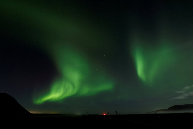 Northern Lights, also called aurora borealis, illuminate the night sky near the town of Thorlakshofn, Iceland, on October 12, 2025. (Photo by Benoit Tessier/Reuters)