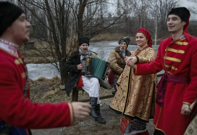 Ukrainians dressed in traditional costumes dance during Orthodox Epiphany celebrations in Kiev January 19, 2015. Orthodox Christians celebrate the religious holiday of Epiphany according to the Gregorian calendar on January 19 by immersing themselves in water. (Photo by Gleb Garanich/Reuters)