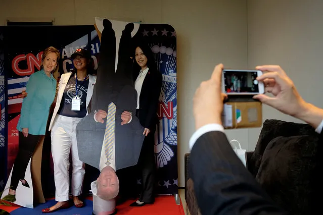 People pose with paper cutouts of U.S. presidential nominees Hillary Clinton (L) and Donald Trump, at an event held by the American Chamber of Commerce in Hong Kong, China November 9, 2016. (Photo by Bobby Yip/Reuters)