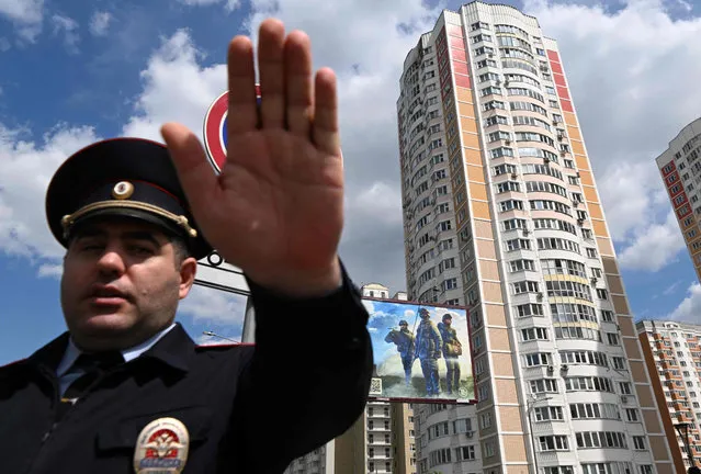 A police officer secures an area outside a damaged multi-storey apartment building after a reported drone attack in Moscow on May 30, 2023. (Photo by Kirill Kudryavtsev/AFP Photo)