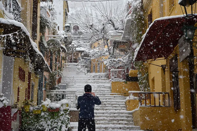 A man makes their way through the popular touristic area of Plaka during a heavy snowfall in Athens on February 16, 2021 in Athens, Greece. Athens, currently in a two-week Covid-19 lockdown, woke up to a rare amount of snow not seen in the city centre for several decades. (Photo by Milos Bicanski/Getty Images)