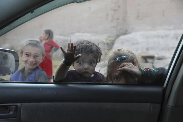 Afghan children look into a window of a car on the outskirts of Jalalabad city east of Kabul, Afghanistan, Thursday, February 4, 2021. (Photo by Rahmat Gul/AP Photo)