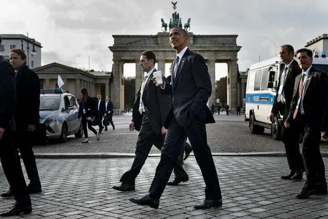US President Barack Obama passes the Brandenburg Gate while walking from the US Embassy to the Adlon Hotel November 17, 2016 in Berlin, Germany. US President Barack Obama is to meet German Chancellor Angela Merkel, widely seen as the new standard bearer of liberal democracy since the election of Donald Trump. On the last leg of his final European tour as president, Obama will underline shared values, try to ease fears about the future of the transatlantic partnership and thank Merkel for her friendship during his two terms, White House officials said. (Photo by Brendan Smialowski/AFP Photo)