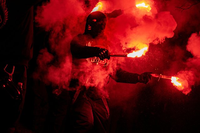 Men in Black group members holding red flares demonstrate  against the coronavirus disease (COVID-19) restrictions, in Copenhagen, Denmark on March 13, 2021. (Photo by Martin Sylvest/Ritzau Scanpix via Reuters)