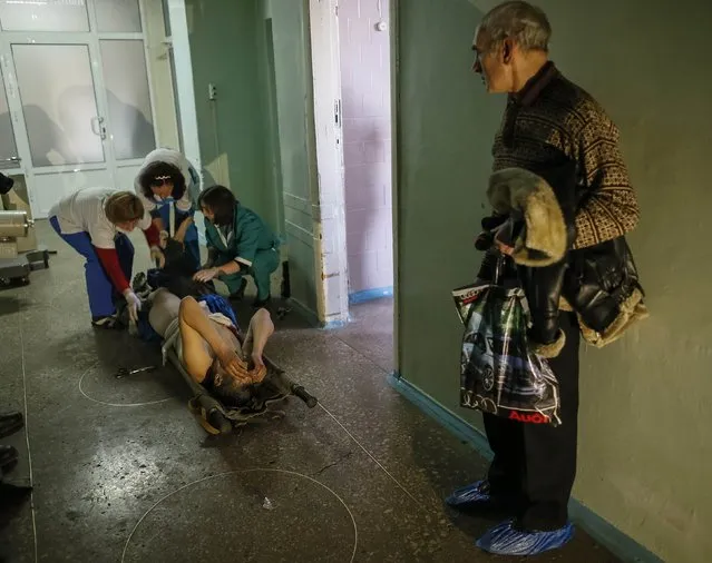 Medics help an injured Ukrainian serviceman as a local resident looks on at a hospital in Artemivsk February 8, 2015. (Photo by Gleb Garanich/Reuters)
