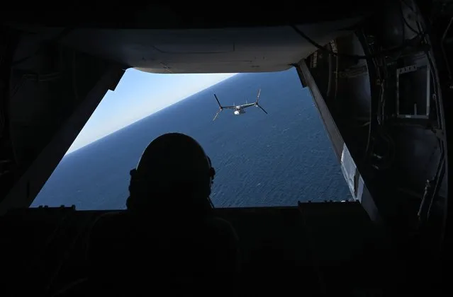 An MV-22B Osprey is seen from the rear door of another Osprey on the flight to land on the USS America off the coast of Brisbane, Australia, 20 June 2023. The USS America, an aircraft carrier-like ship that's part of the Seventh Fleet, has been on exercises in the Indo-Pacific and is visiting Queensland. (Photo by Darren England/EPA)