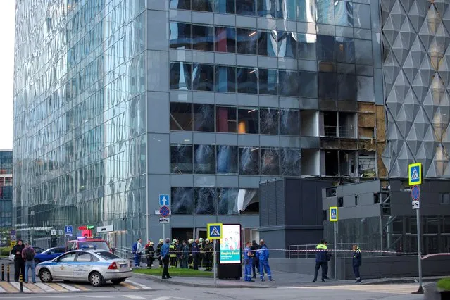 Members of the emergency services gather outside a damaged office building in Moscow, Russia on July 30, 2023, after a drone attack that Russian officials blamed on Ukraine. (Photo by Reuters/Stringer)