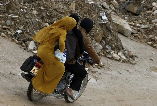 Syrian women hold milk while riding a motorcycle near an informal settlement for Syrian refugees in Bar Elia, Bekaa valley, Lebanon, January 6, 2016. More than 1 million Syrians are enduring another winter as refugees in Lebanon. For some, it is their fifth in a row, displaced by a war that has driven 4.4 million Syrians into neighbouring states from where many are trying to reach Europe. (Photo by Jamal Saidi/Reuters)