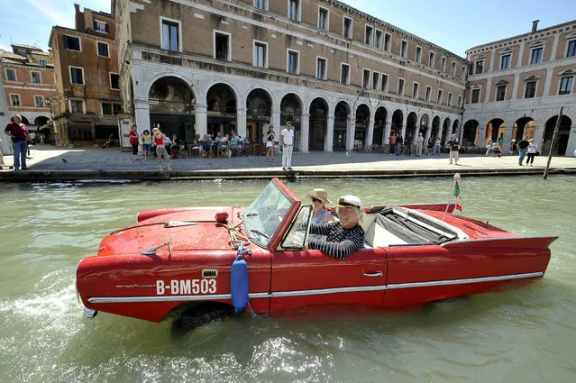 Bernd Weise, of the Amphicar Club Berlin, pilots his 1961 Amphicar down the Grand Canal in Venice May 28, 2009. The German-built amphibious car, which uses a Triumph Herald engine, is capable of over 110 kph (70mph) by road and 8 knots on water. Its driver a needs regular driving licence and a boat licence. (Photo by Michele Crosera/Reuters)