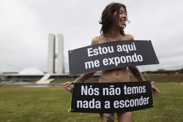 A member of the non-governmental organisation Avaaz takes part in a protest against the Brazilian Senate, calling to abolish the secret ballot on key votes, in front of the National Congress in Brasilia September 18, 2013. Posters in Portuguese read, “Here I am exposed, we have nothing to hide”. (Photo by Ueslei Marcelino/Reuters)
