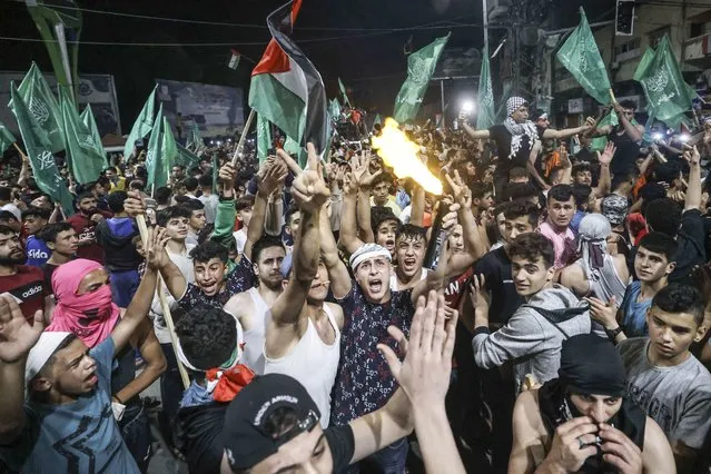 Palestinians celebrate the ceasefire brokered by Egypt between Israel and the ruling Hamas Islamic movement in Gaza City on May 21, 2021. A ceasefire between Israel and Hamas, the Islamist movement which controls the Gaza Strip, came into force early on May 21, 2021 after 11 days of deadly fighting that pounded the Palestinian enclave and forced countless Israelis to seek shelter from rockets. (Photo by Mahmud Hams/AFP Photo)