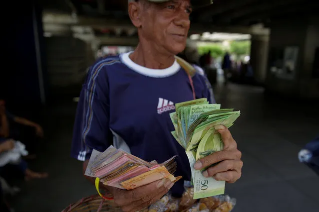 A street vendor counts bolivar notes near Venezuela's Central Bank in Caracas, Venezuela December 16, 2016. (Photo by Marco Bello/Reuters)