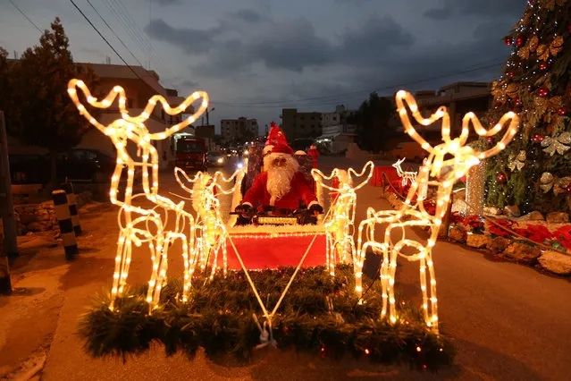 A man dressed as Santa Claus rides a Christmas decorated vehicle in Jiyeh, south Lebanon December 23, 2016. (Photo by Aziz Taher/Reuters)