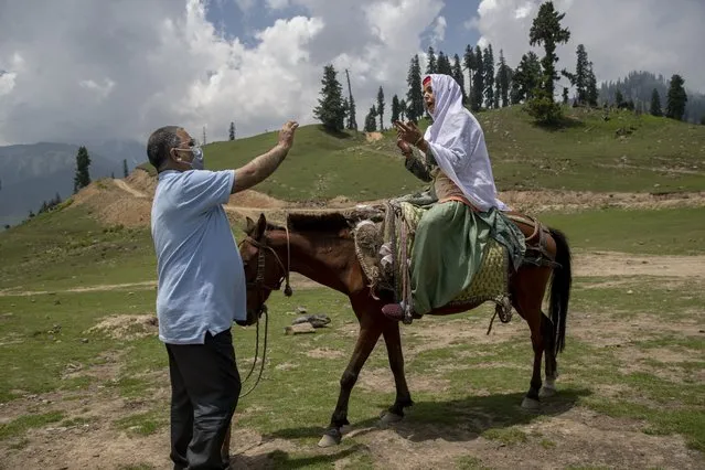 Dr. Tajamul-Hussain Khan, chief medical officer unsuccessfully tries to convince a Kashmiri nomad woman sitting on horse back who refused to let her 30 year old son to be vaccinated during a COVID-19 vaccination drive in Tosamaidan, southwest of Srinagar, Indian controlled Kashmir on June 21, 2021. (Photo by Dar Yasin/AP Photo)