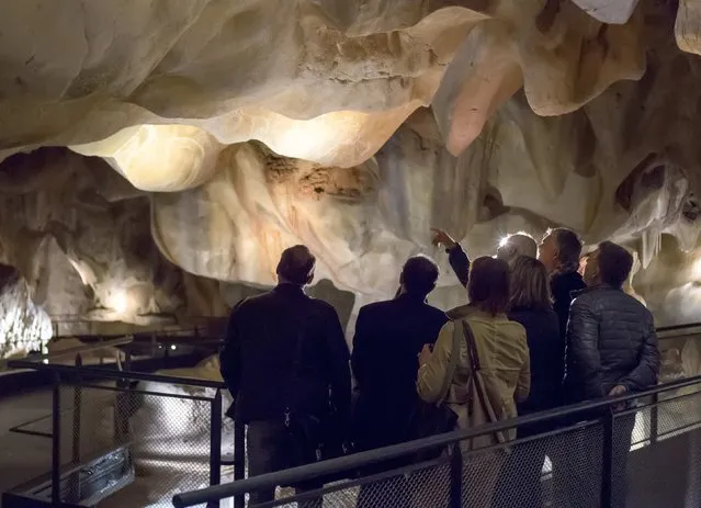 Visitors look at pre-historic engravings during a press visit of the Cavern of Pont-d'Arc project site in Vallon Pont d'Arc April 8, 2015. (Photo by Robert Pratta/Reuters)
