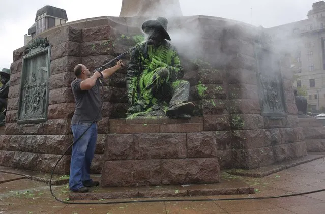 A council worker washes off green paint on a statue of the memorial for Afrikaner hero Paul Kruger in central Pretoria, South Africa, 08 April 2015. The color was supposedly painted on the statue by leftist Economic Freedom Fighters (EFF) party members after a country wide debate started surrounding statues of former white leader of the country. Prominent Afrikaans personalities reportedly are planning to chain themselves to the Paul Kruger statue. (Photo by Kim Ludbrook/EPA)