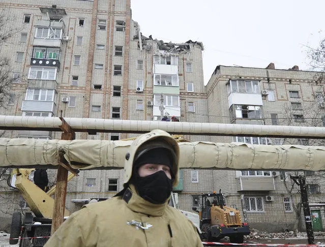 An Emergency services worker at the scene of the destroyed top floor of a apartment building in the city of Shakhty, Russia, Monday, January 14, 2019. A suspected gas explosion at an apartment building in southern Russia killed at least one person and injured two others early Monday, authorities said. (Photo by AP Photo/Stringer)