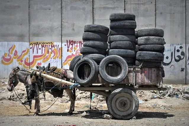 A donkey cart is loaded with tyres along a roadside in Kabul on July 27, 2021. (Photo by Sajjad Hussain/AFP Photo)
