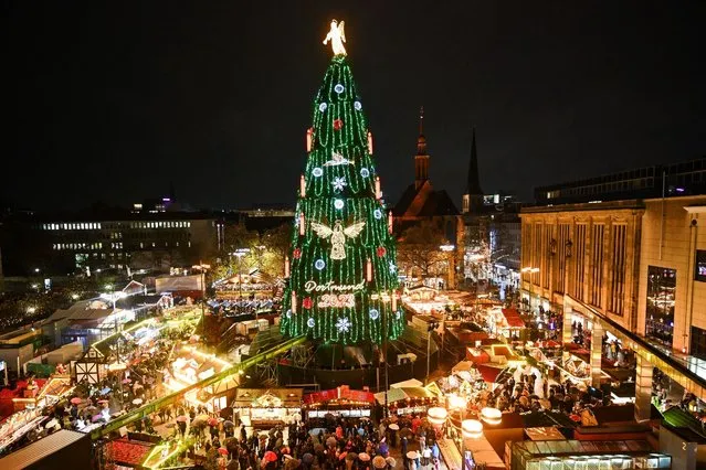 A photo taken on November 27, 2023 shows a Christmas tree made of more than 1000 individual red spruces from the Sauerland region, after it was officially inaugurated with its illumination, at the Christmas market in Dortmund, western Germany. According to organizers, the Christmas tree is said to be the world's largest. (Photo by Ina Fassbender/AFP Photo)