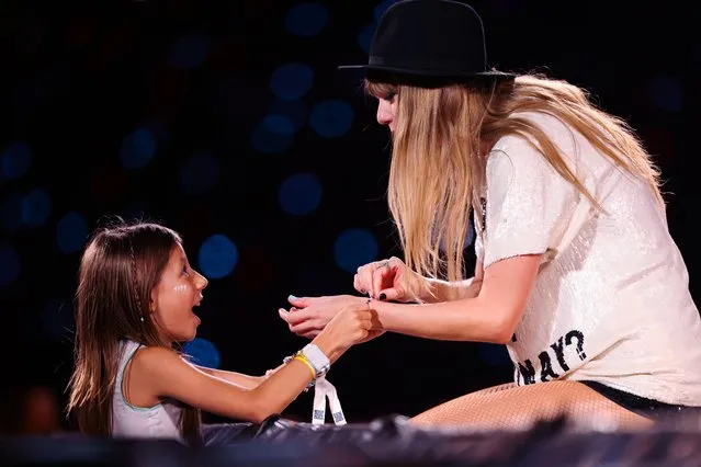 A young fan exchanges friendship bracelets with American singer-songwriter Taylor Swift as she performs onstage during “Taylor Swift | The Eras Tour” at Allianz Parque on November 24, 2023 in Sao Paulo, Brazil. (Photo by TAS2023 via Getty Images)