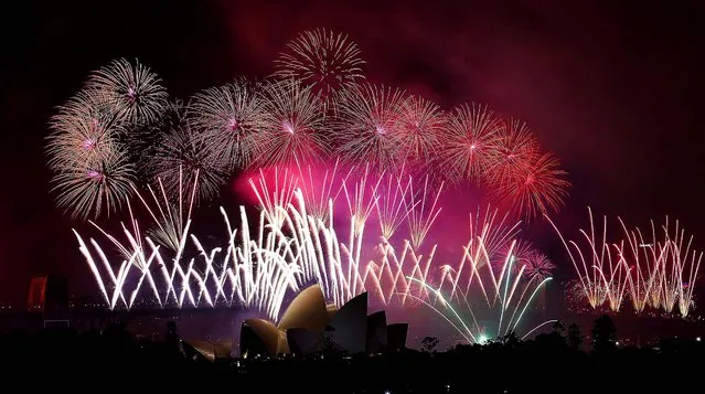 Fireworks explode over the Harbour Bridge and the Opera House during New Year's Eve celebrations in Sydney, Australia. (Photo by Rob Griffith/Associated Press)