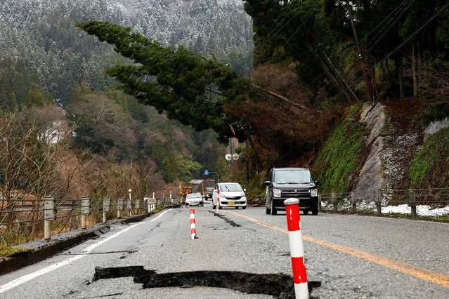 Cars drive past a damaged road, in the aftermath of an earthquake, in Wajima, Ishikawa Prefecture, Japan on January 7, 2024. (Photo by Kim Kyung-Hoon/Reuters)