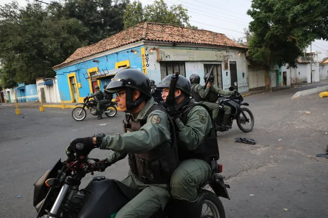 Motorized officers of the Bolivarian National Guard patrol during clashes in Urena, Venezuela, near the border with Colombia, Saturday, February 23, 2019. (Photo by Rodrigo Abd/AP Photo)