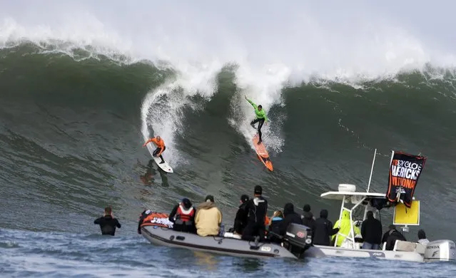 Shane Dorian, left, and Ben Wilkinson, right, catch a wave during the third heat of the first round of the Mavericks Invitational big wave surf contest Friday, January 24, 2014, in Half Moon Bay, Calif. (Photo by Eric Risberg/AP Photo)