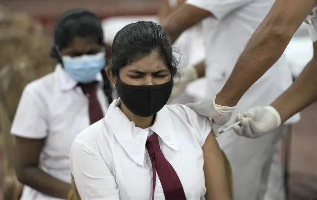 A Sri Lankan school student receives a COVID-19 vaccine in Colombo, Sri Lanka, Friday, October 15, 2021. Sri Lanka is vaccinating 18- and 19-year-olds against the coronavirus as it expands the shots to students. After beginning with older people, Sri Lanka has now vaccinated 57% of its 22 million population. (Photo by Eranga Jayawardena/AP Photo)