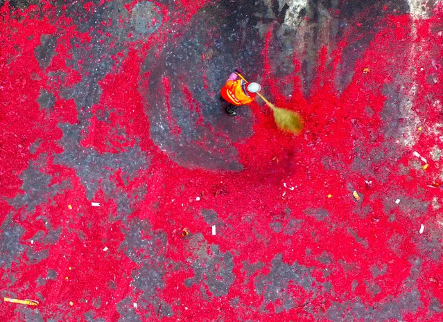 Aerial view of a sanitation worker cleaning debris of firecrackers set off by businessmen on February 4, 2017 in Shenyang, Liaoning Province of China. Businessmen set off firecrackers on the eighth day of the Lunar New Year because eight (“Ba” in Chinese) has the similar pronunciation with “Fa” (meaning wealth or fortune), which brings burden on sanitation workers. (Photo by VCG/VCG via Getty Images)