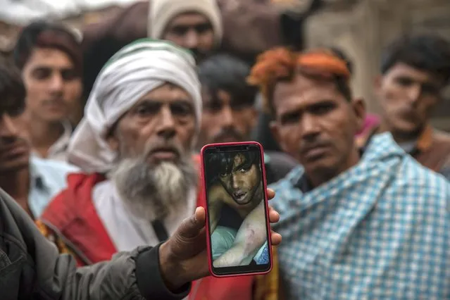 In this Tuesday, January 22, 2019 photo, a man holds a phone showing a video of Muslim farmer Saghir Khan, 25, moments after being beaten, Mirzapur, India. Most of the attacks by so-called cow vigilantes from Hindu groups have targeted Muslims, who make up 14 percent of India's 1.3 billion people. Hindus make up about 80 percent of the population. (Photo by Bernat Armangue/AP Photo)