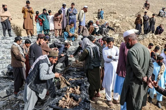 Afghan residents and municipality workers sort human remains recovered from a grave at the Sarbani area of Khost province on February 12, 2024. A mass grave containing some 100 bodies dating from Afghanistan's Soviet-backed government era has been discovered in the country's eastern Khost province, local officials said on on February 12. (Photo by AFP Photo)