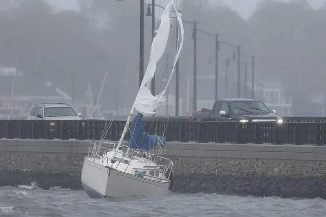 A sail boat runs aground into the Bridge Street causeway in Dartmouth, Mass. on Wednesday, October 27, 2021 as nor'easter storm slams into the region. (Photo by Peter Pereira/The Standard-Times via AP Photo)