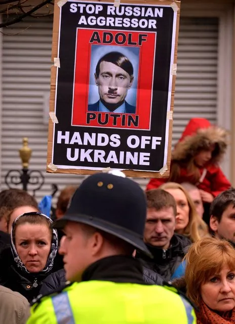 British-based Ukrainians gather outside the Russian Embassy in London to protest against the build-up of troops in the Crimea region, on March 2, 2014. The demonstrators chanted and held banners demanding “Hands off Ukraine”. (Photo by John Stillwell/PA Wire)