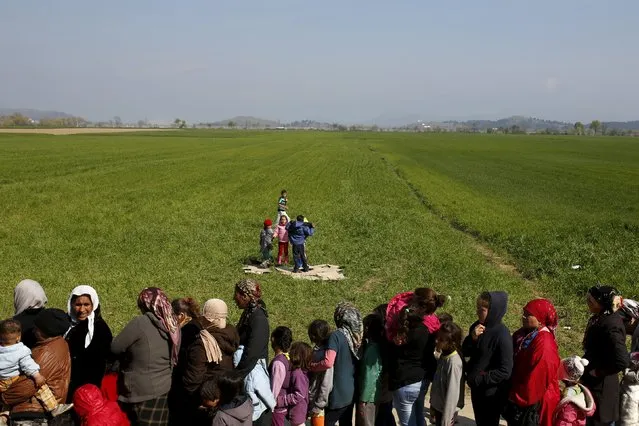 Migrants and refugees queue to receive food at a makeshift camp at the Greek-Macedonian border near the village of Idomeni, Greece, March 28, 2016. (Photo by Marko Djurica/Reuters)