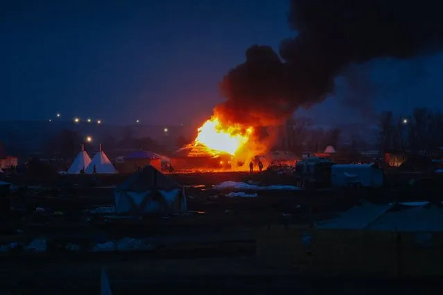 Campers set structures on fire in preparation of the Army Corp's 2pm deadline to leave the Oceti Sakowin protest camp on February 22, 2017 in Cannon Ball, North Dakota. (Photo by Stephen Yang/Getty Images)