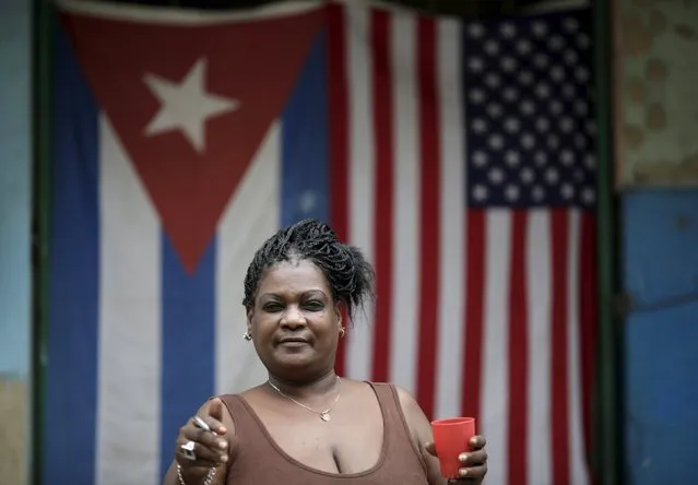 Irma Diaz, 55, a housewife, poses for a photograph in front of the Cuban and U.S. flags in Havana, March 25, 2016. Regarding Obama's historic visit to the island, Diaz said “I am happy with the friendship between Raul (Castro) and Obama”. Struggling under a U.S. embargo and still only cautiously emerging from a Soviet-style economy that prohibited almost all private enterprise, many Cubans find it hard to make ends meet. Residents of Havana hope that U.S. President Barack Obama's historic visit to Cuba last month will bring material improvements to their lives. (Photo by Ueslei Marcelino/Reuters)