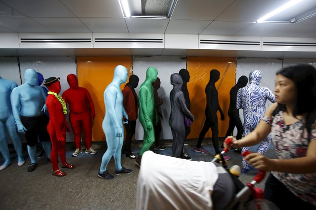 Participants wearing Zentai costumes, or skin-tight bodysuits from head to toe, walk in an underpass as they take part in a march down the shopping district of Orchard Road during Zentai Art Festival in Singapore May 23, 2015. (Photo by Edgar Su/Reuters)