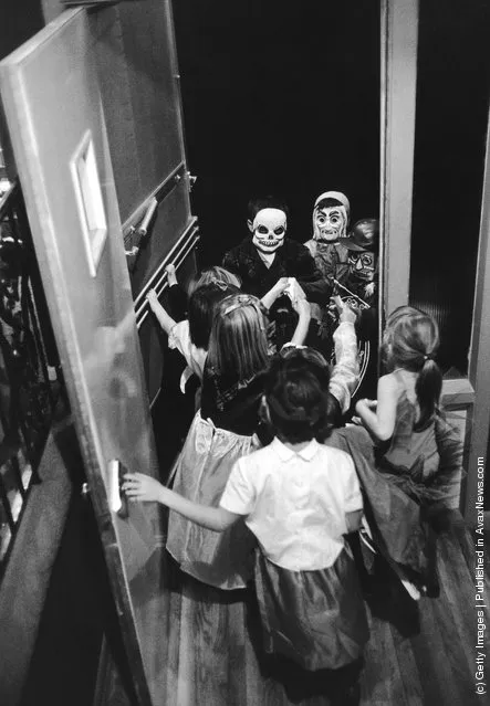 Children in costumes arriving at a Halloween party, circa 1960